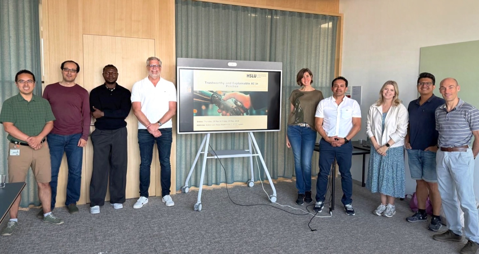 The course cohort and lecturers standing together beside an HSLU screen reading “Trustworthy and Explainable AI in Practice.”
