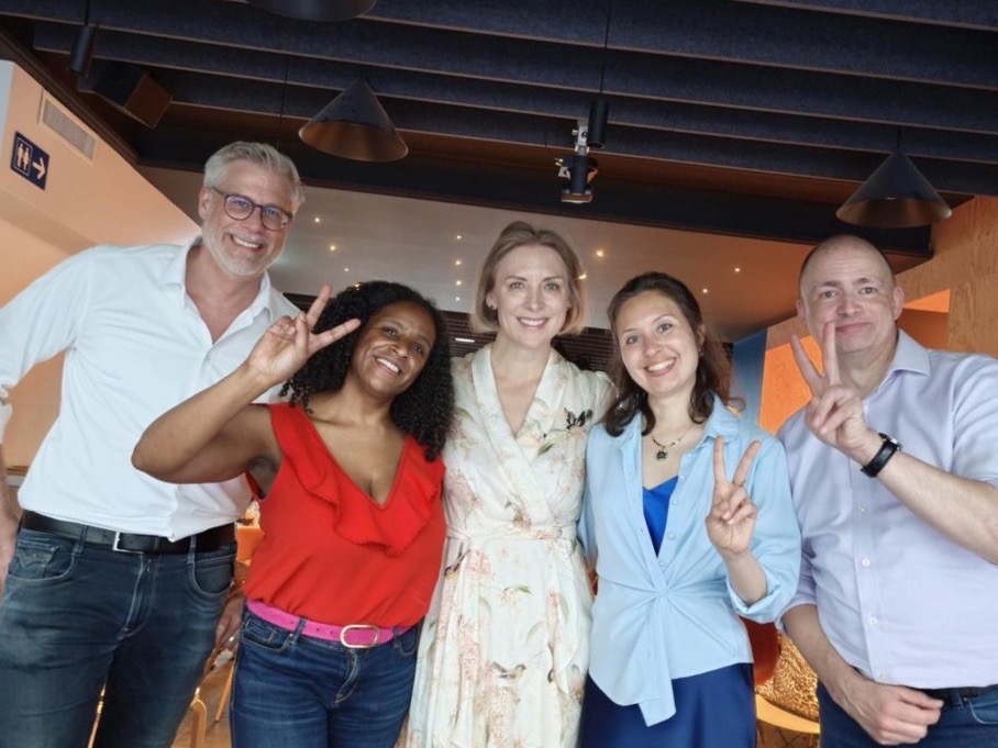The original photo: five Trustworthy AI Circle participants smiling and holding up peace signs after the session.