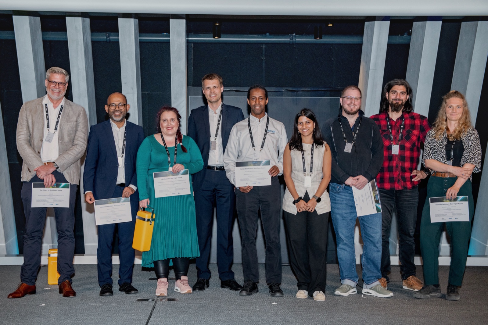The award recipients standing together on stage with their certificates at the 2026 IEEE Swiss Conference on Data Science and AI.